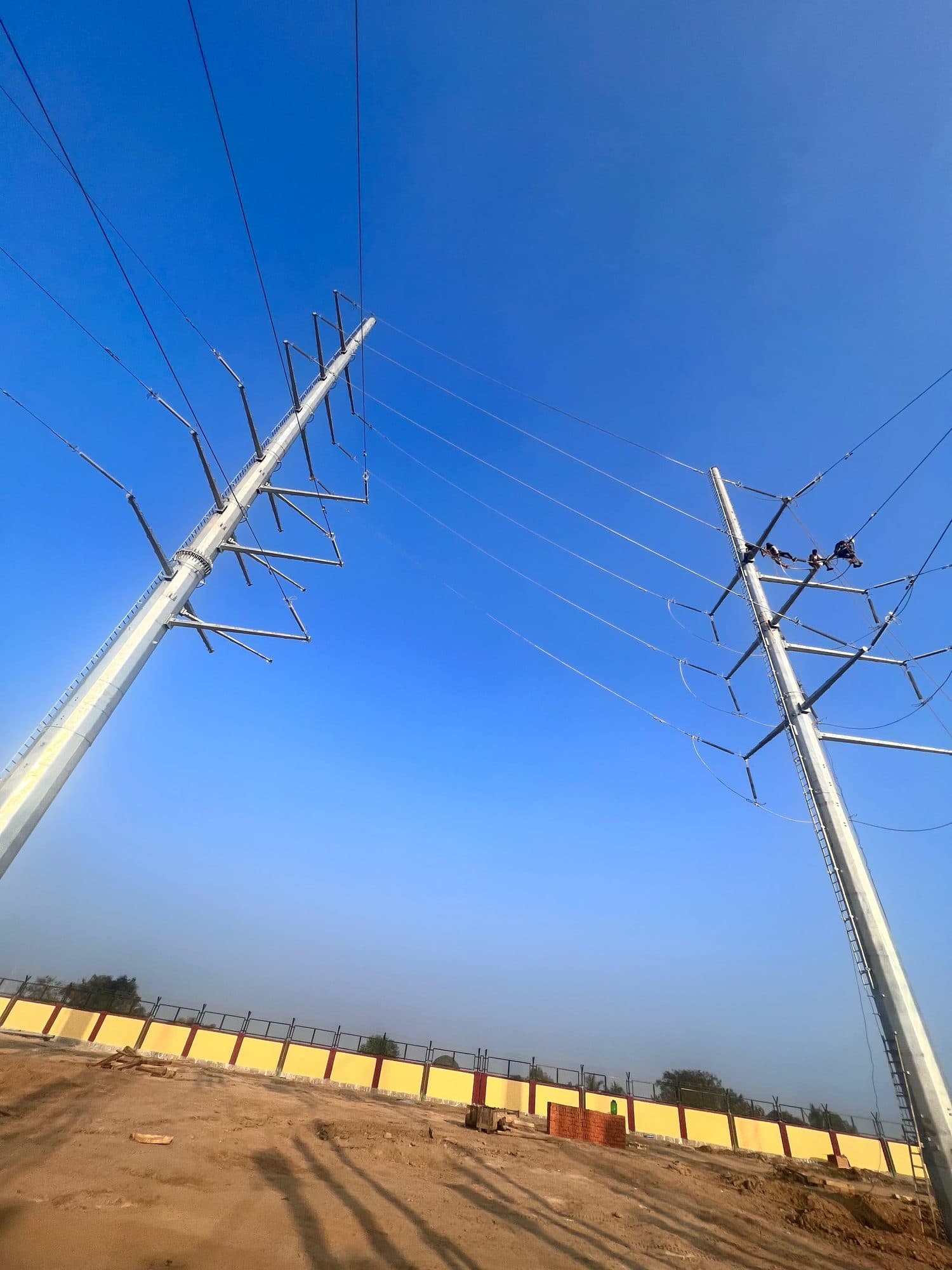 Steel monopoles and their conductors against a deep blue sky