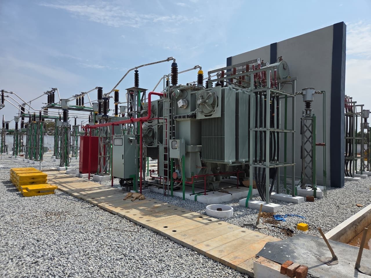 A power transformer beside its firewall, fire-protection piping round it