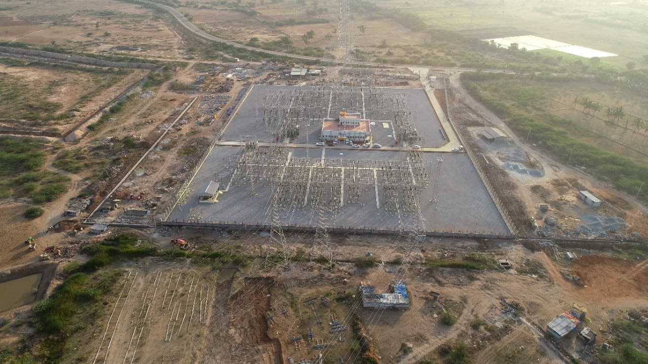 Aerial view of a completed sub-station: two switchyards either side of the control building