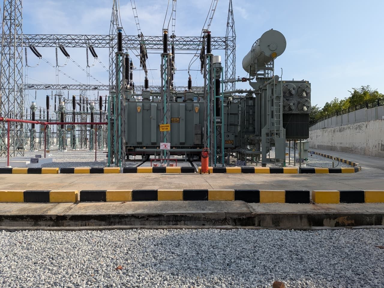 A power transformer in its bay, with its fire-protection piping