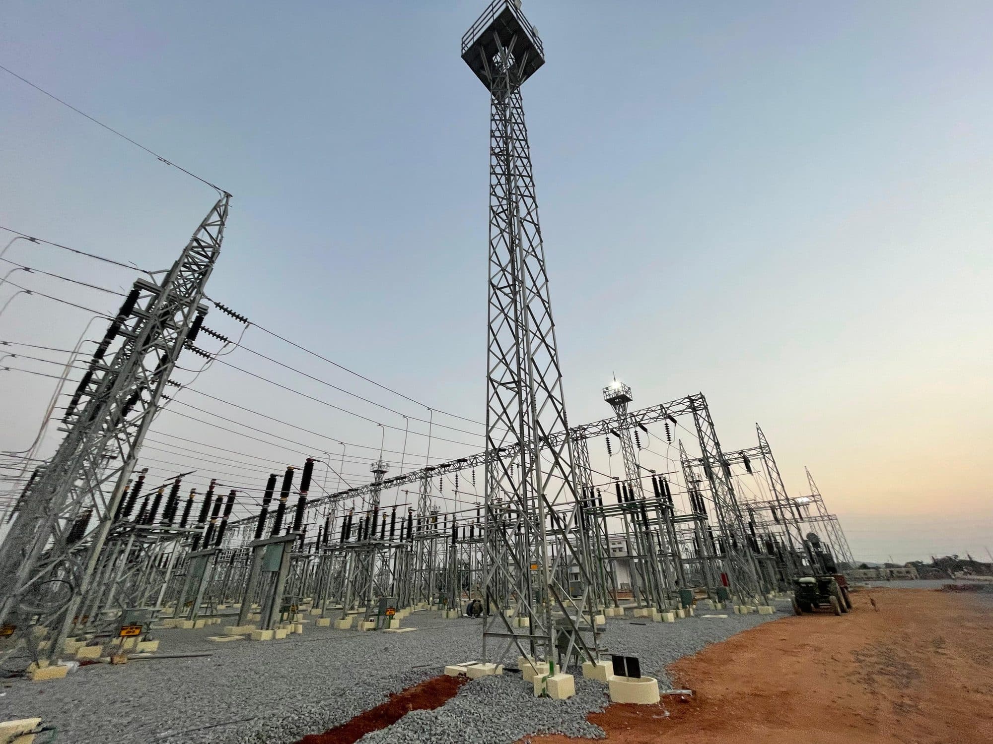 A switchyard's bays and its high lighting mast in late light