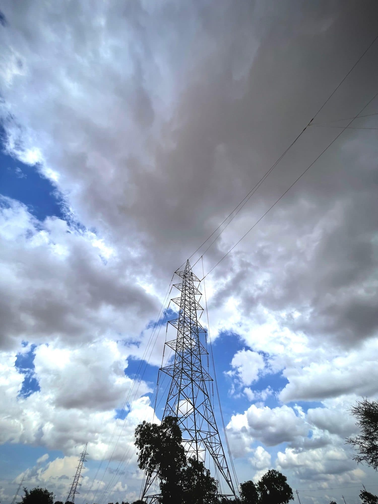 A transmission tower under a dramatic cloudscape
