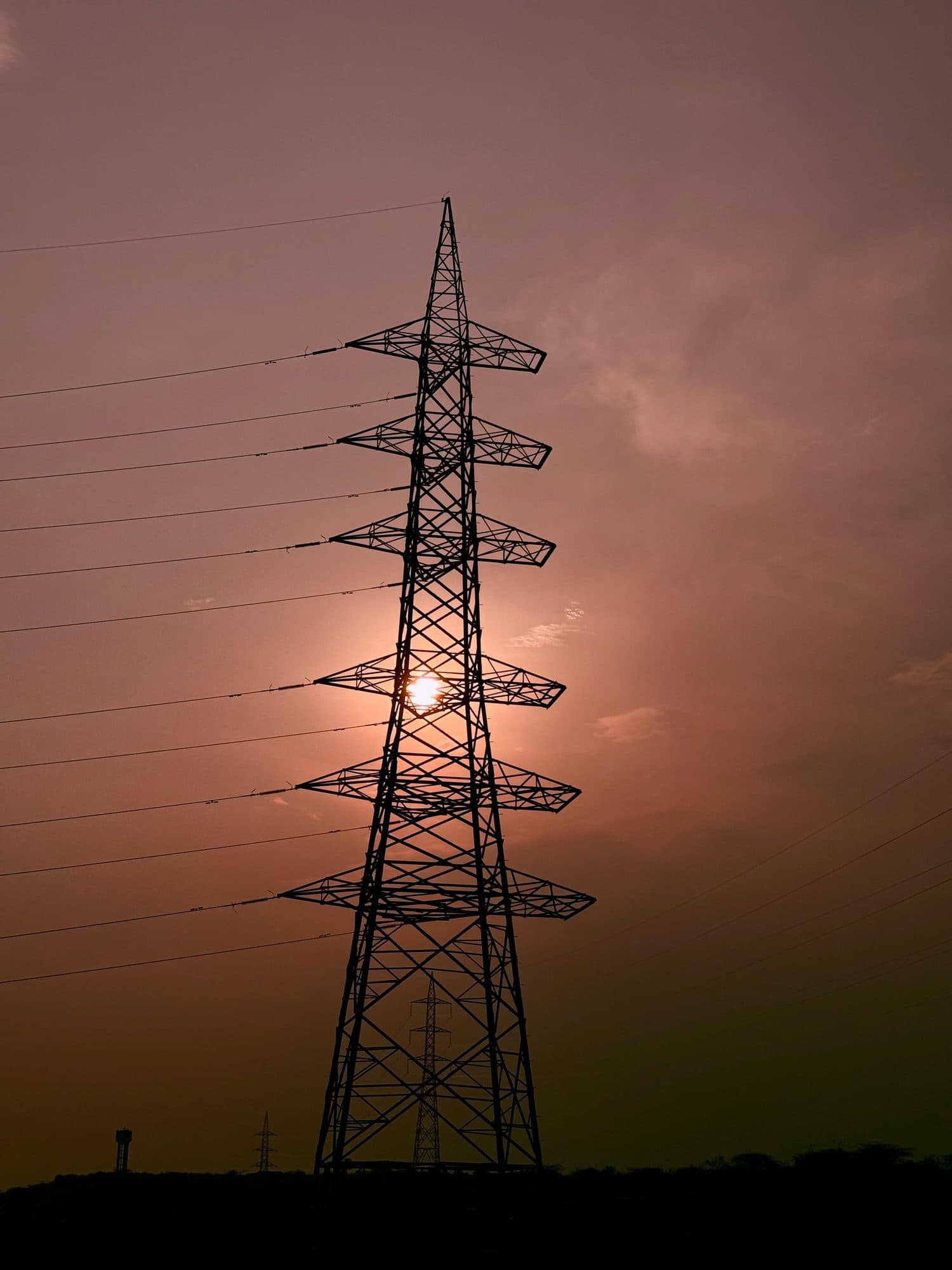 A tower in silhouette against a red evening sky