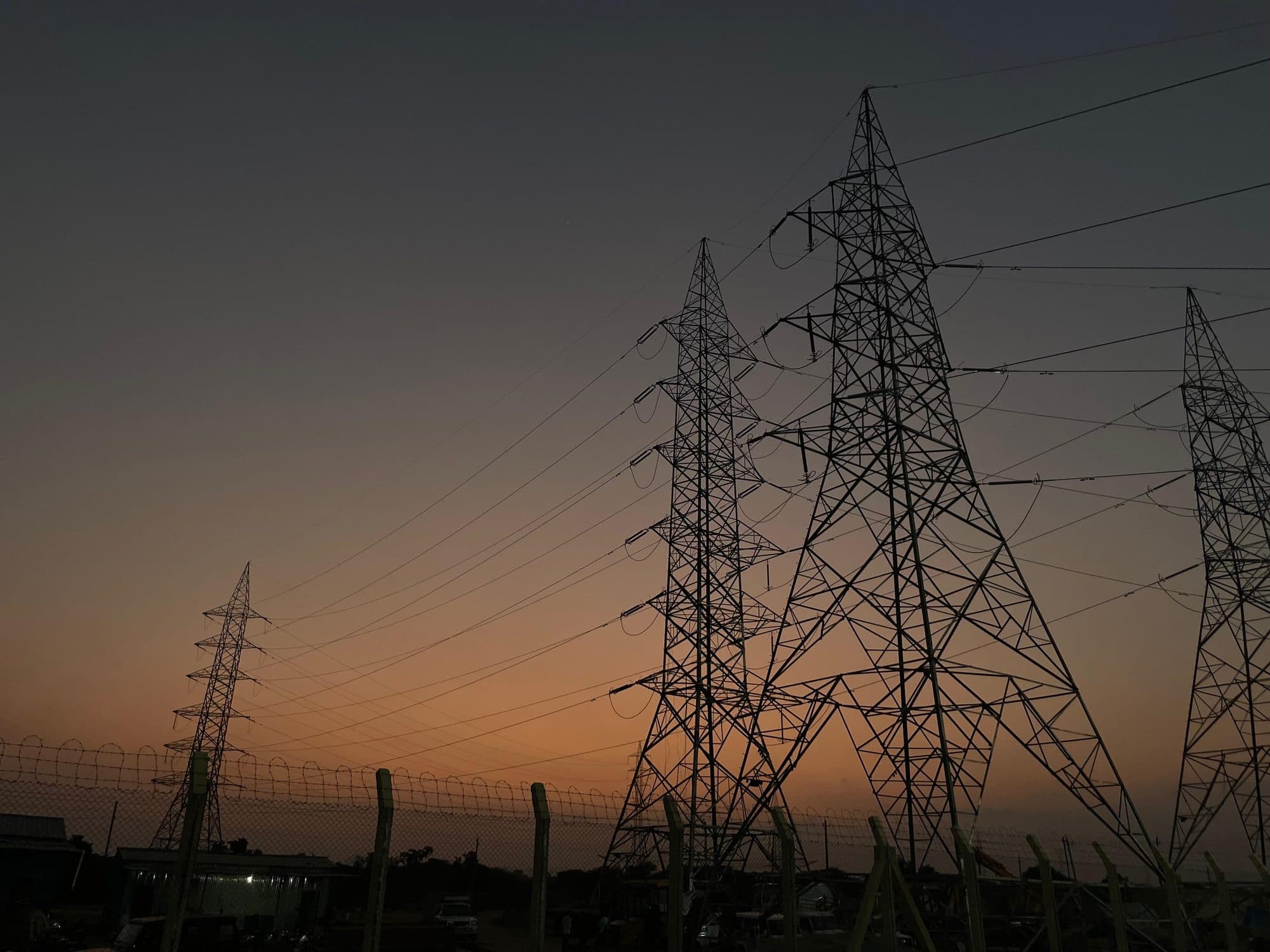 Lattice towers silhouetted against an orange dusk