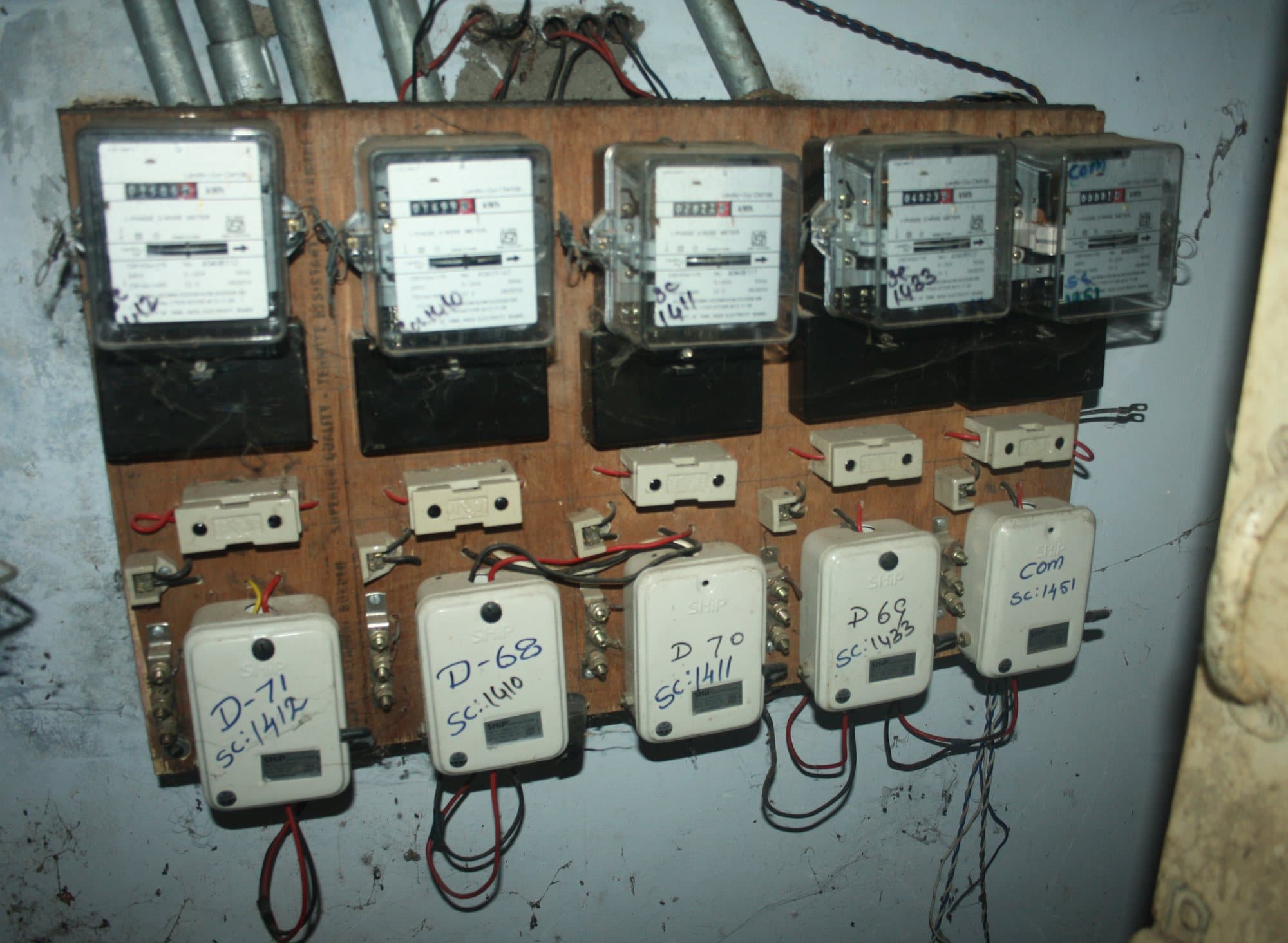 A board of five apartment energy meters with their cut-outs